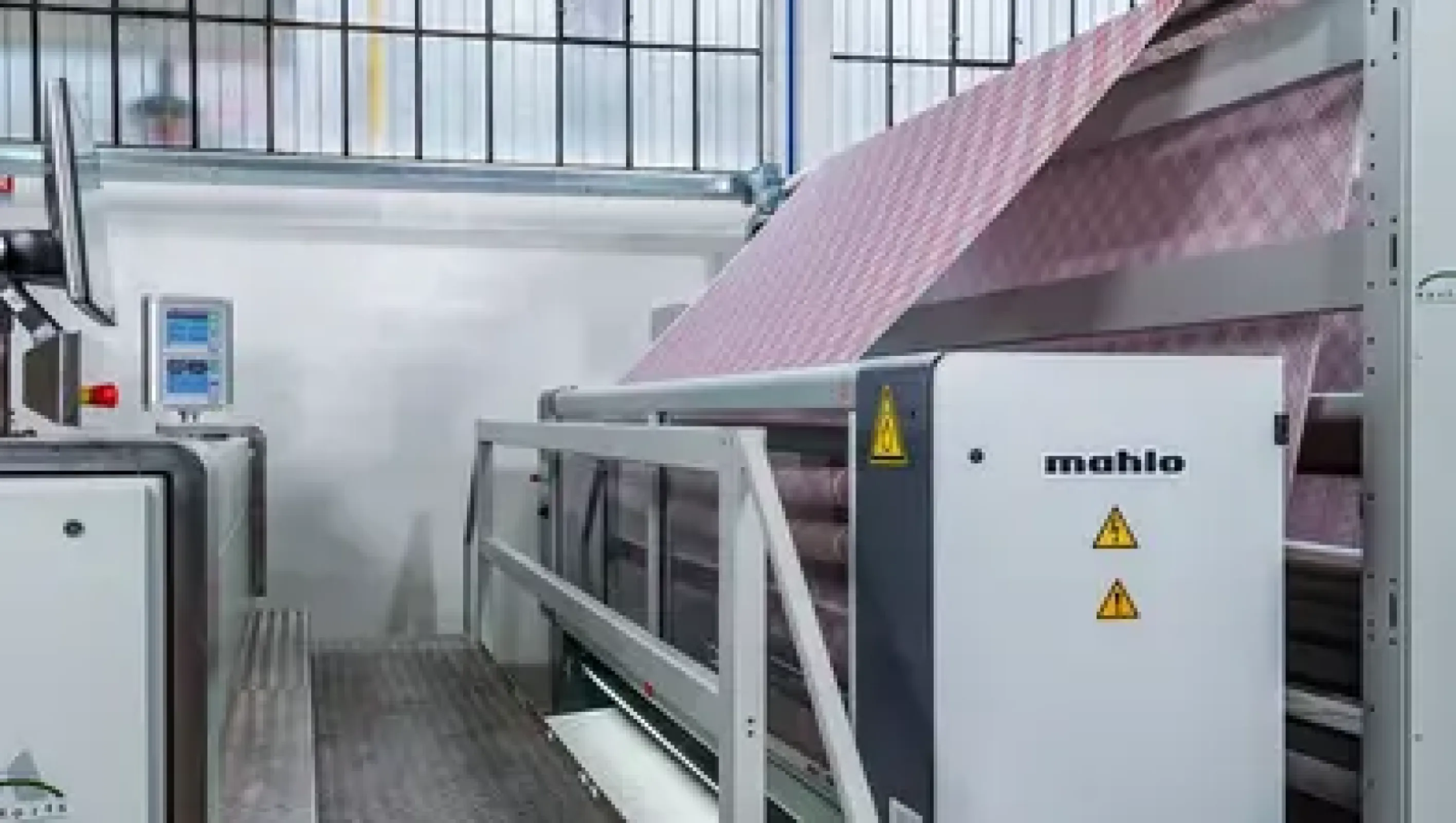 At the inlet, the Orthopac RVMC automatic weft straightener supplies the stenter frame with straight fabric. (Pezzoli / Italy)