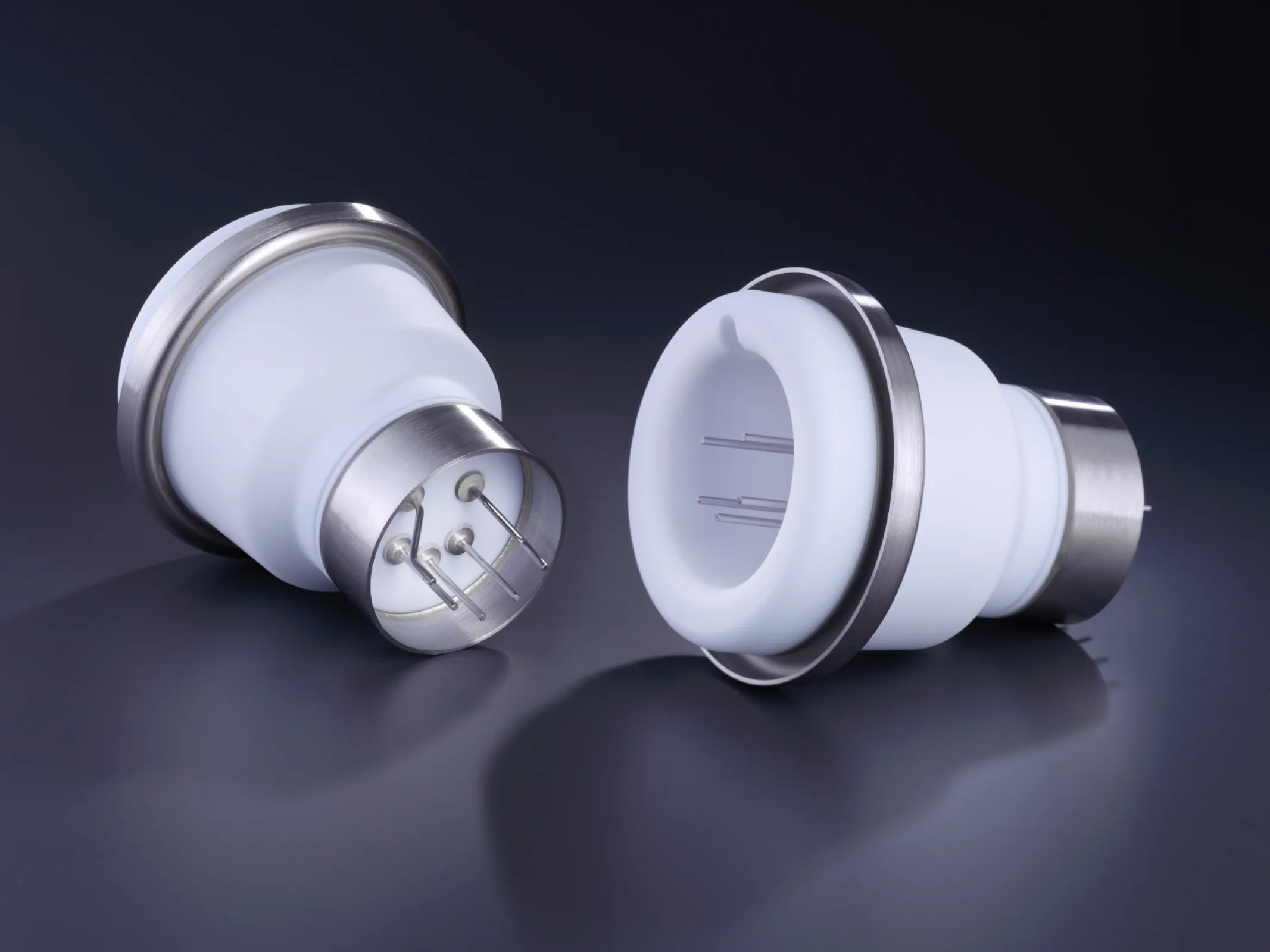 Metal-ceramic brazed assemblies with electrical feedthroughs. The image shows two high-performance components featuring alumina ceramic bodies and metallized flanges, designed for vacuum and high-voltage applications.