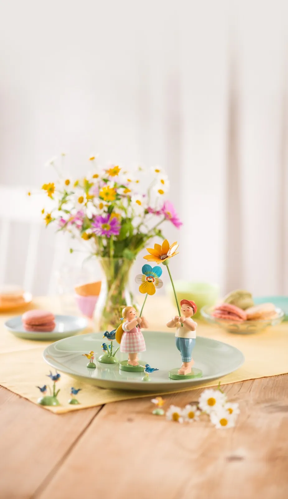 Spring table decoration with the girl with pansies and the boy with gazania.