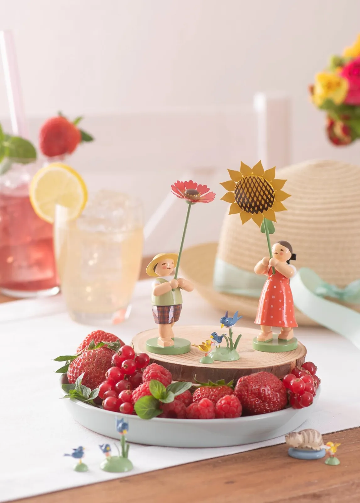 Summery decoration with the girl with sunflower and the boy with helenium