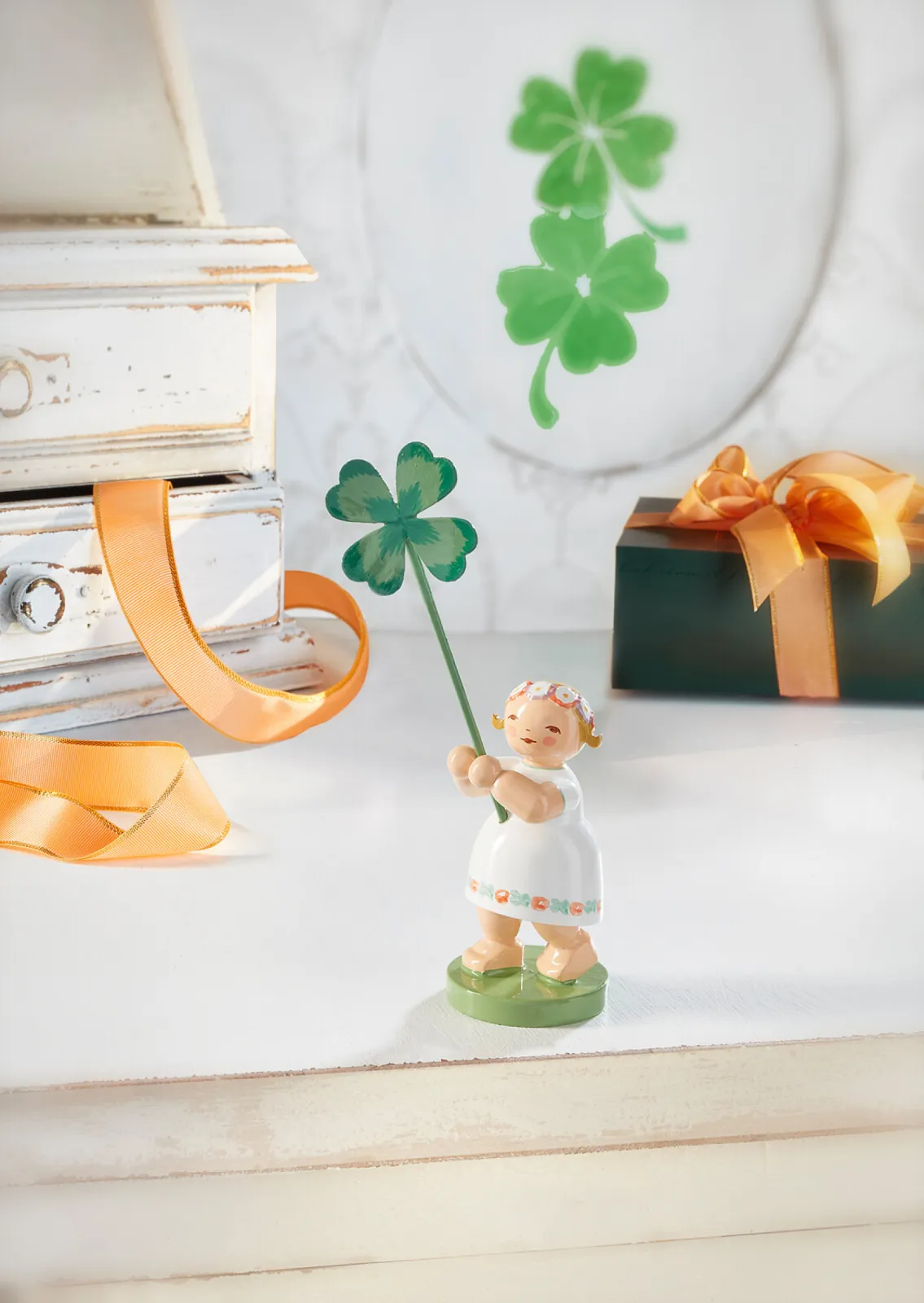 The girl in the delicate white dress had to hunt around for a long time to find the four-leaf clover that she now holds so proudly.