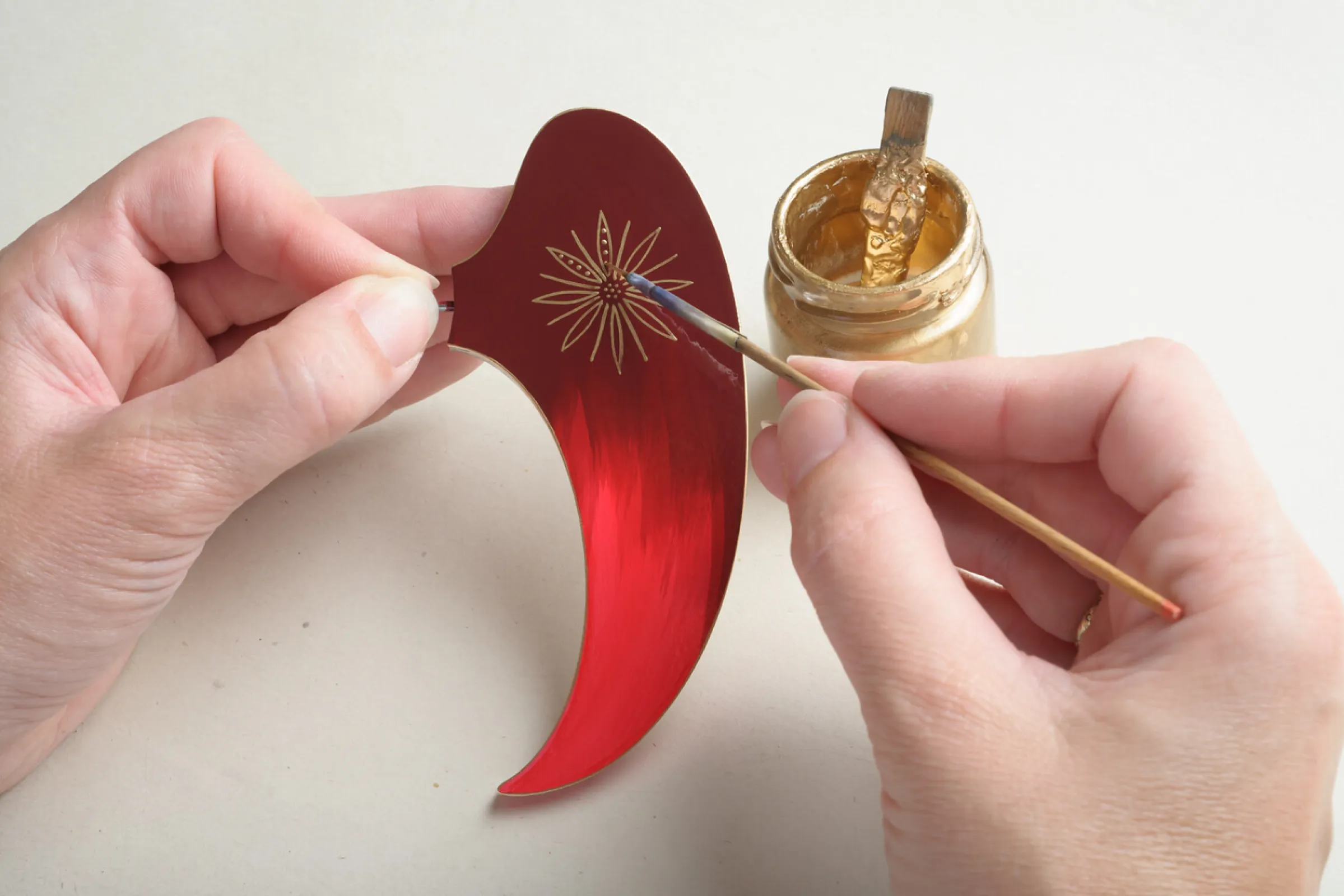 Detailed ornaments are created on the large wings with a finely honed brush.