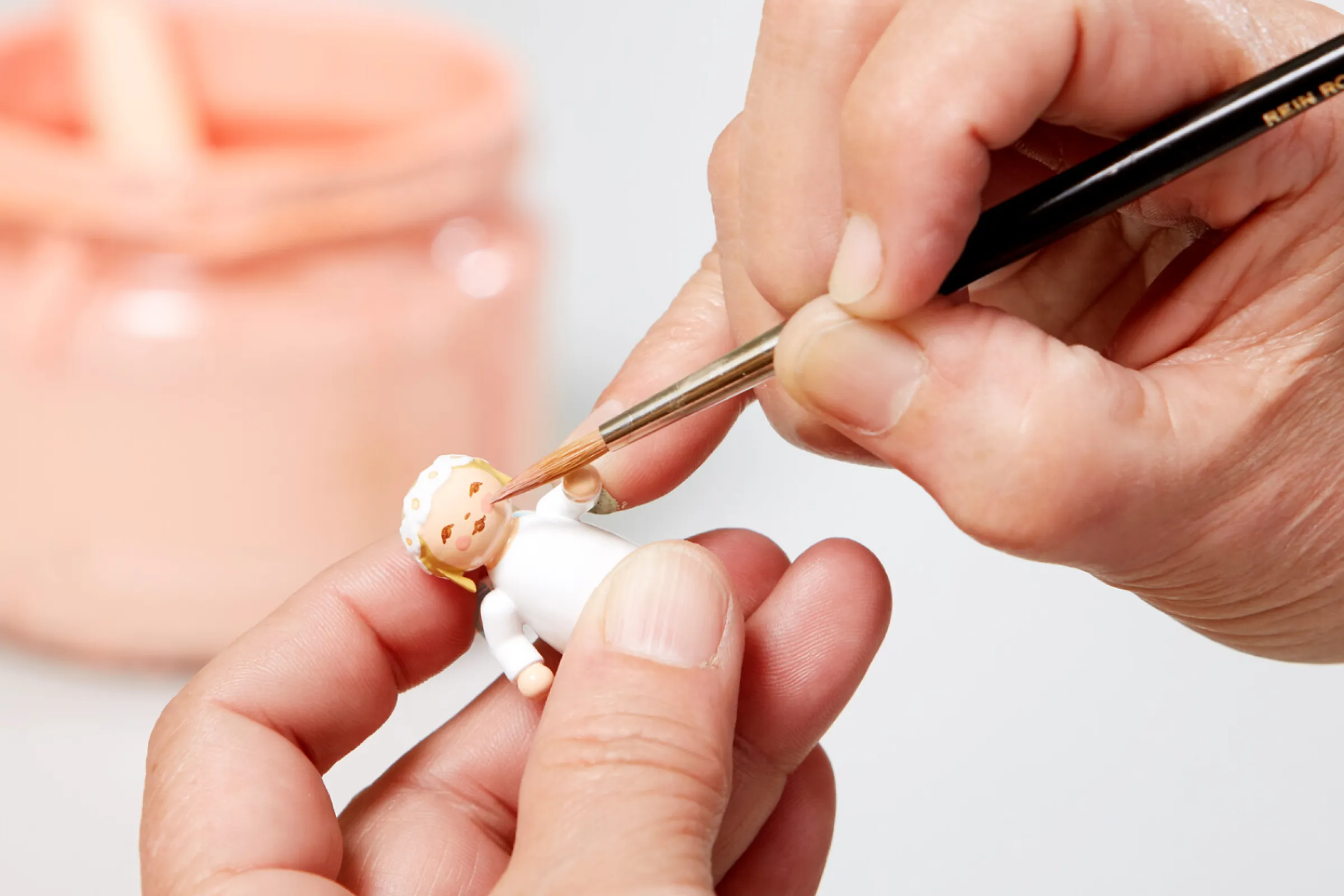 As a final step in the painting process, the face of the figures is applied with fine brushstrokes.