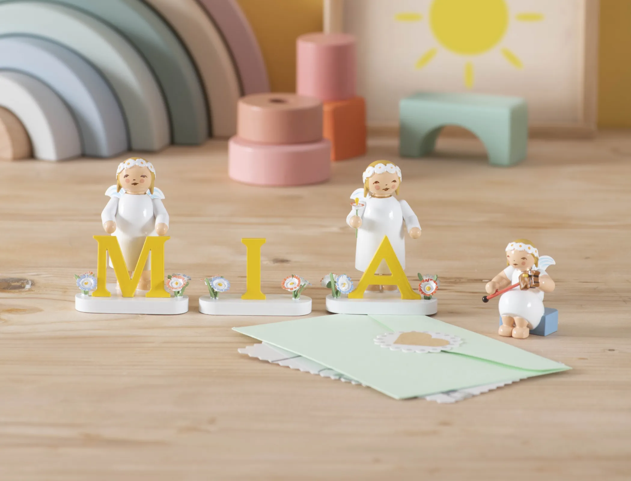 The marguerite angels in white dresses and the sun-yellow letters can be used to create personalised messages.