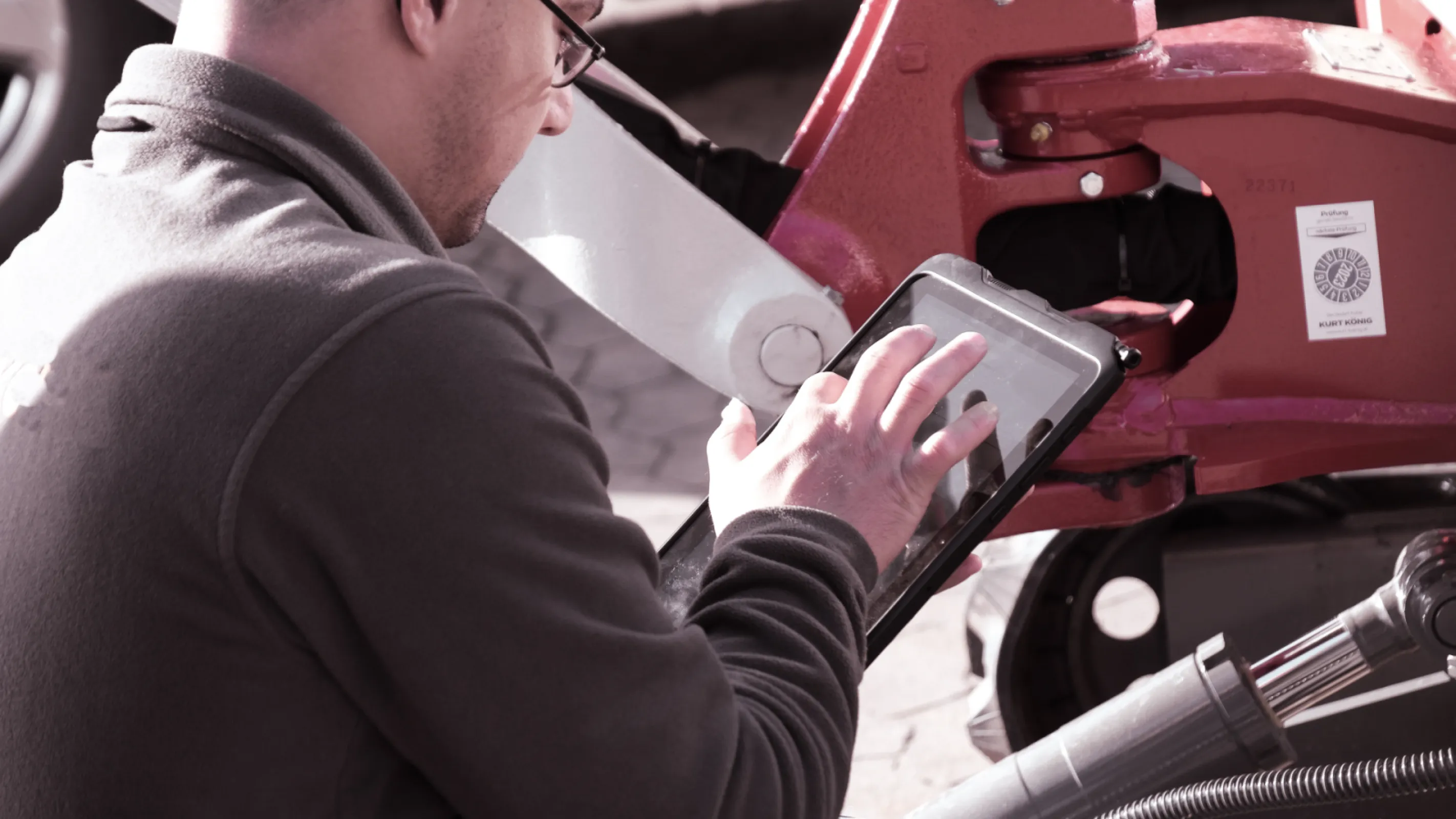 Technician performing a machine check using the SAM mobile app during a handover or inspection.
