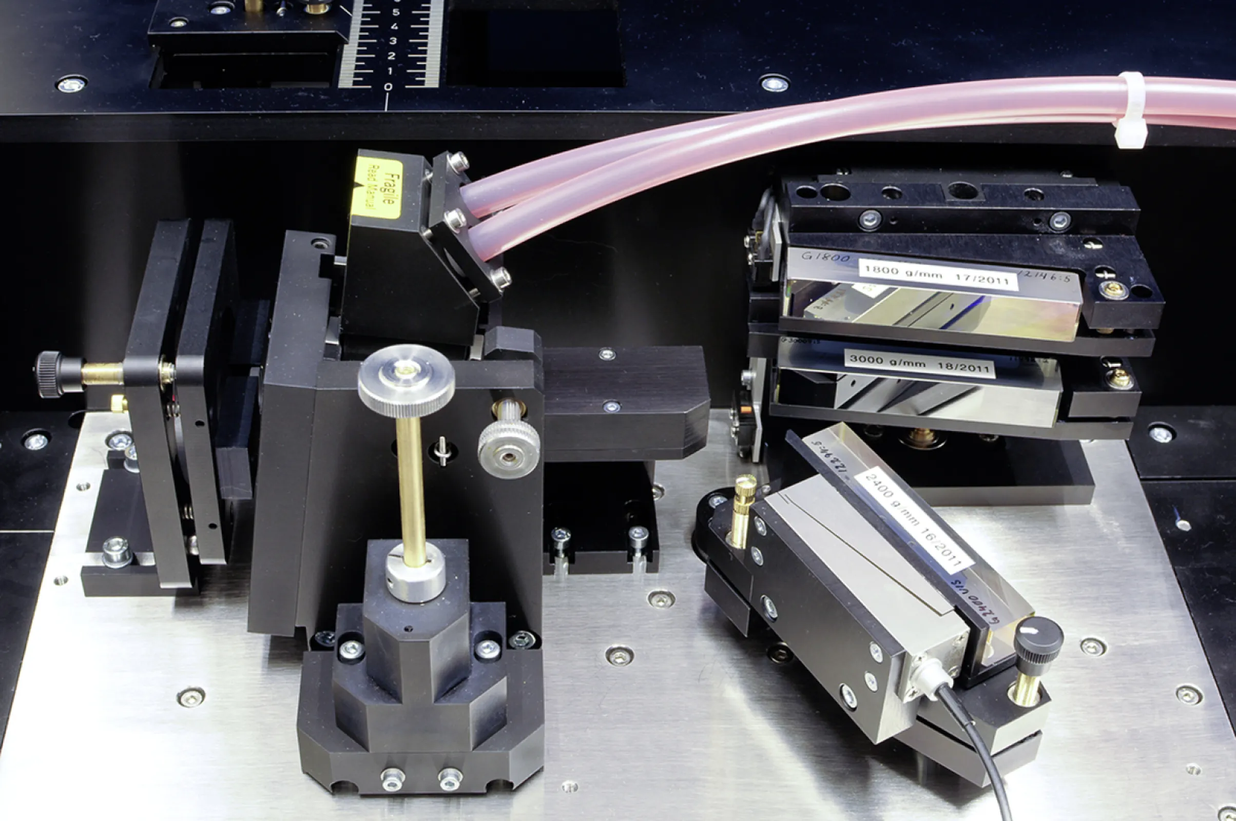 Narrow-linewidth dye laser resonator assembly with automated grating lift and piezo wavelength control