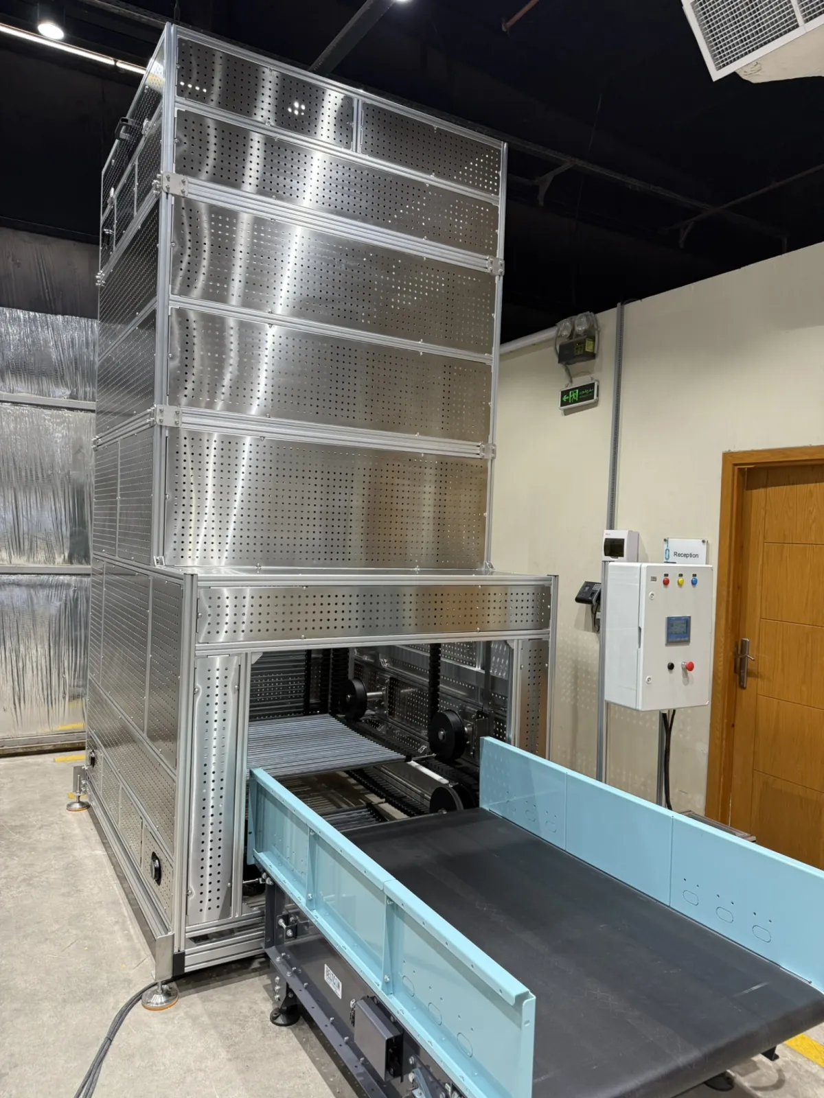 TRAMAK Continuous Vertical Conveyor (CVC) with ourfeed belt conveyor. Fully cladded for save operation