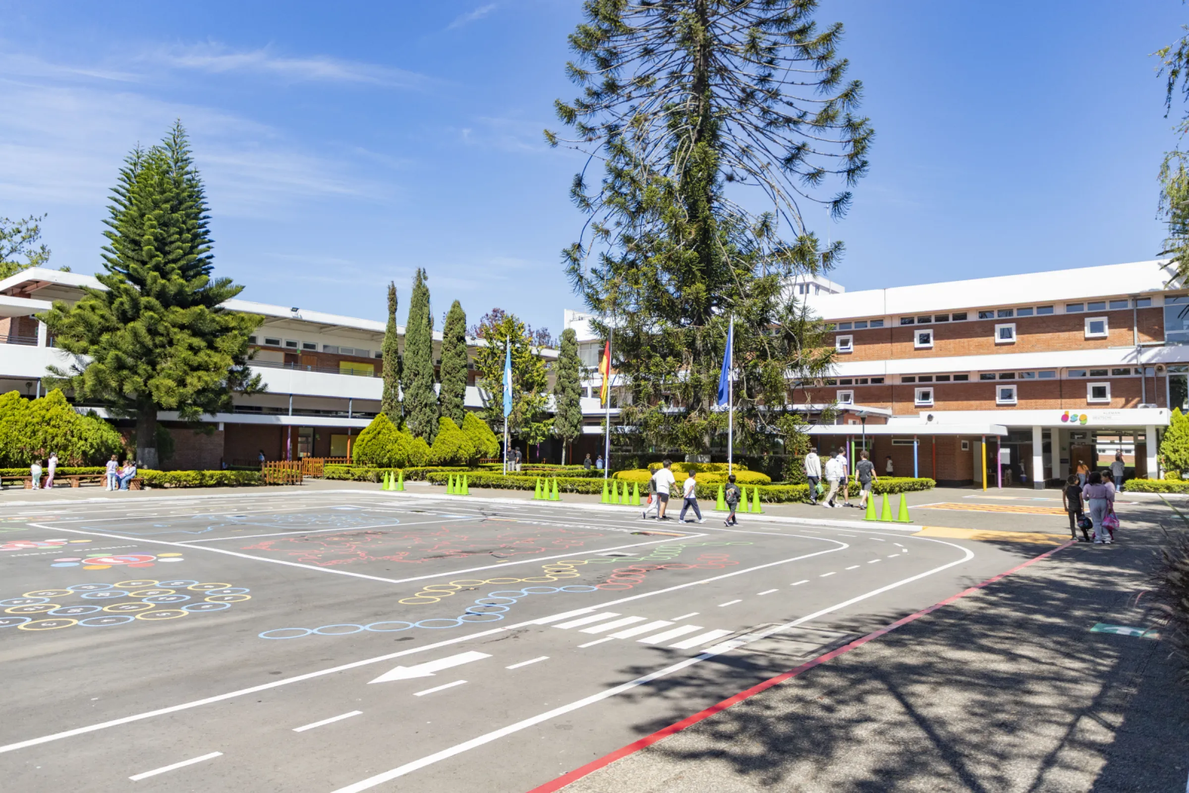 At the entrance of the Deutsche Schule Guatemala, the flags of Germany, Guatemala, and Europe are displayed.