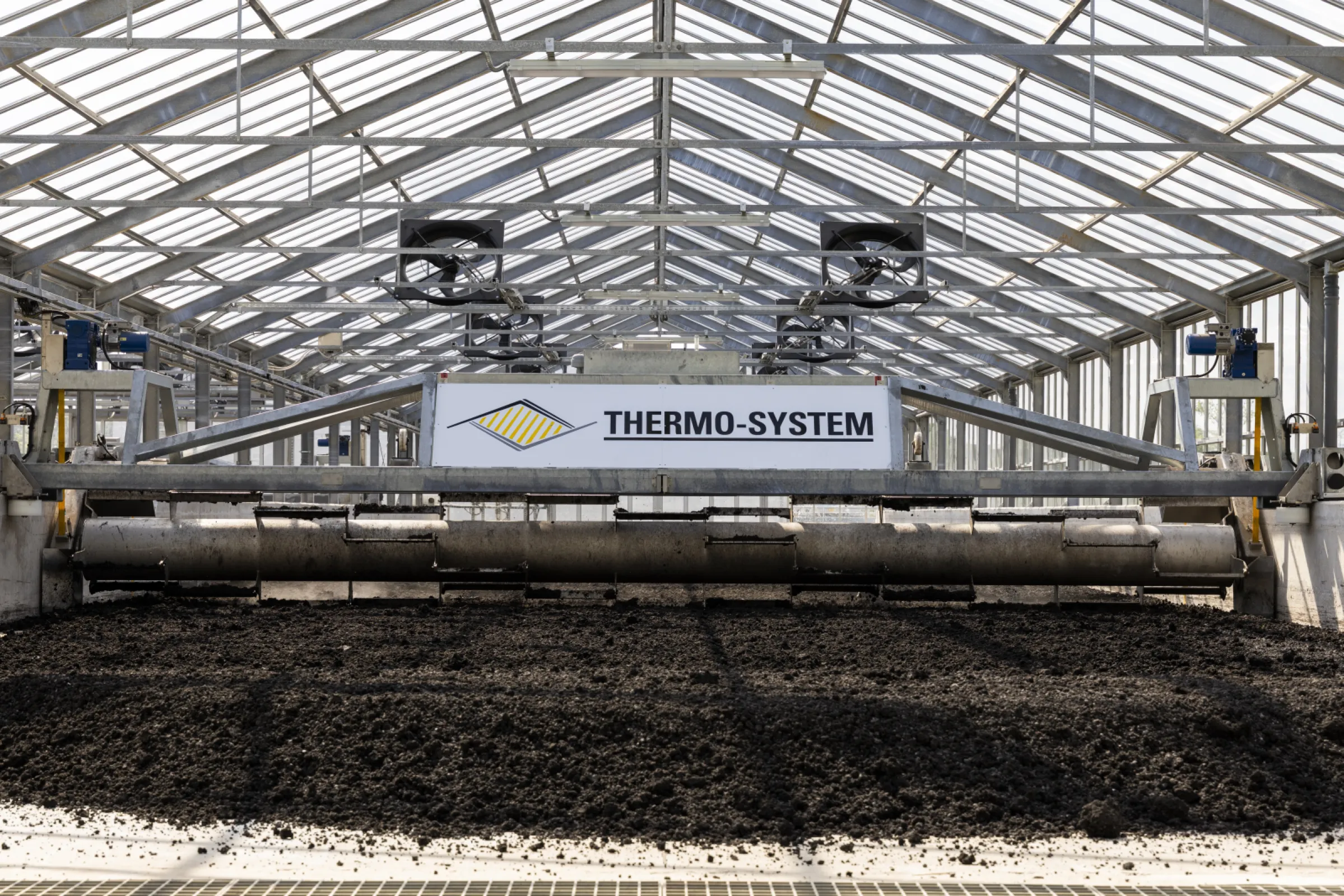The SludgeTiller is a fully automatic turning device for standard system concepts with hall widths of up to 12.2 m. It essentially consists of a stable mobile frame and a rotating drum with turning tools that covers the entire width of the drying bed.