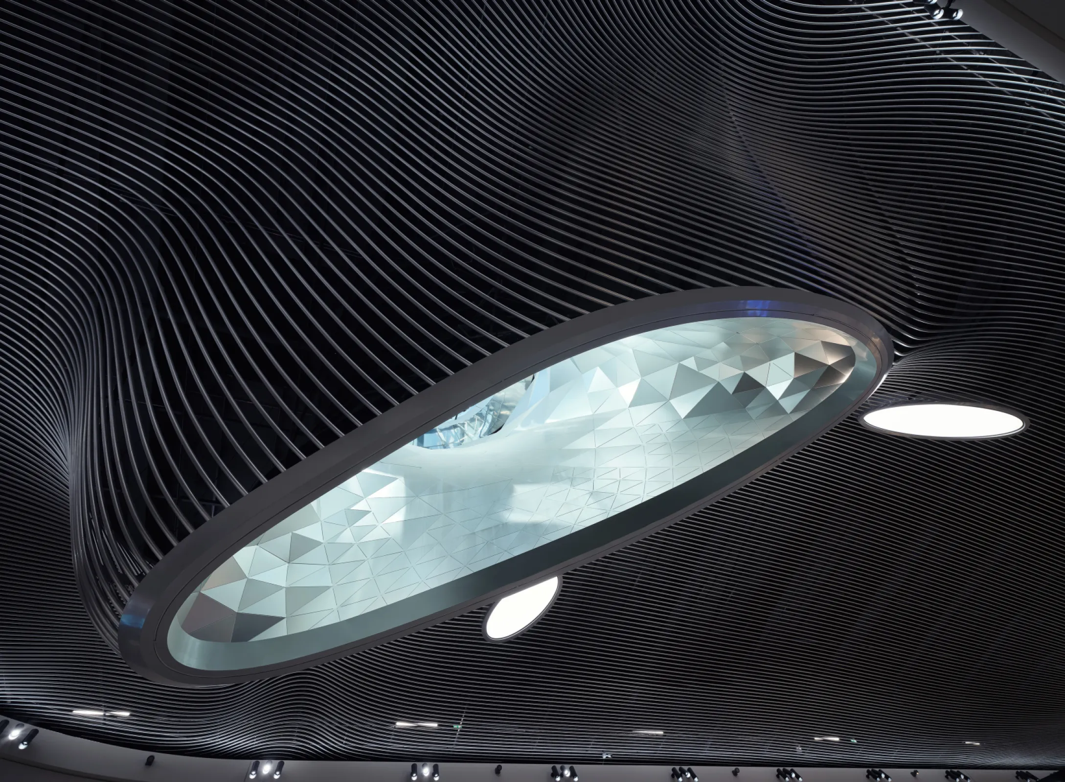 A sculptural cloud of 18,000 metres of aluminium tubing channels natural light into the marketplace. Computational design orchestrates light, orientation and moments of calm, helping travellers reconnect with their natural rhythms. Photo: Taufik Kenan